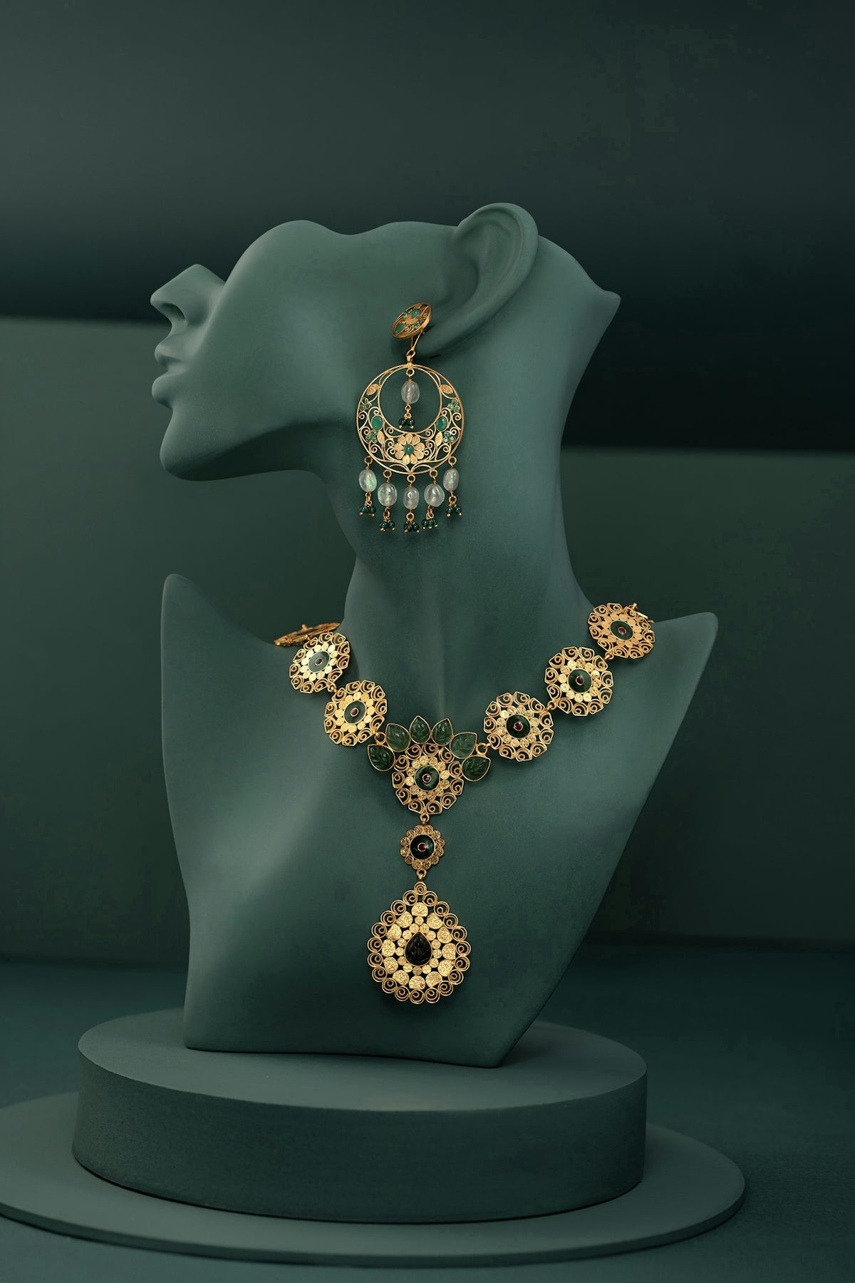 A necklace and earring on display on a mannequin