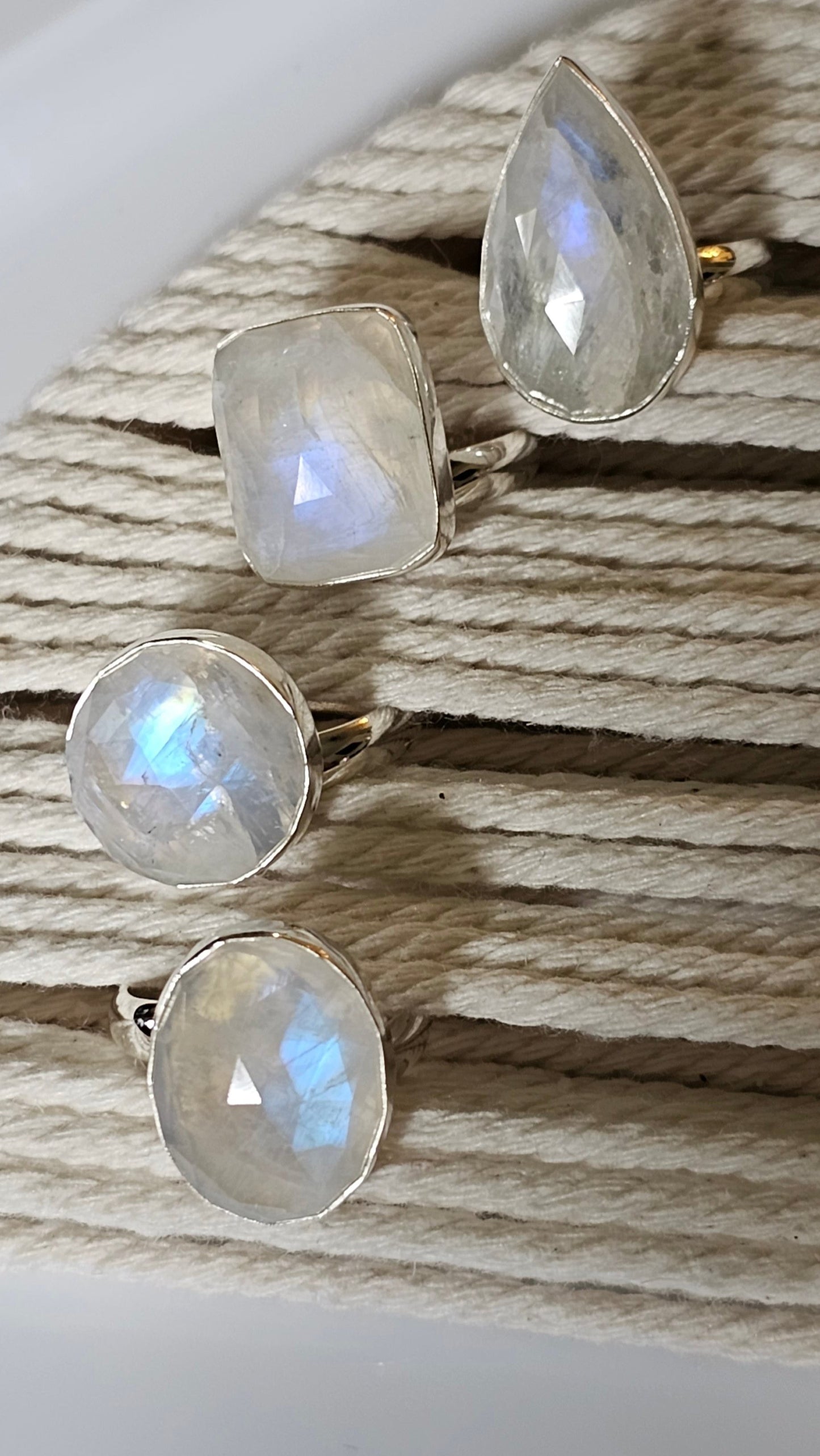 Rainbow moonstone set in solid sterling silver ring setting which is displayed in a boho string holder that product a lot of fire!