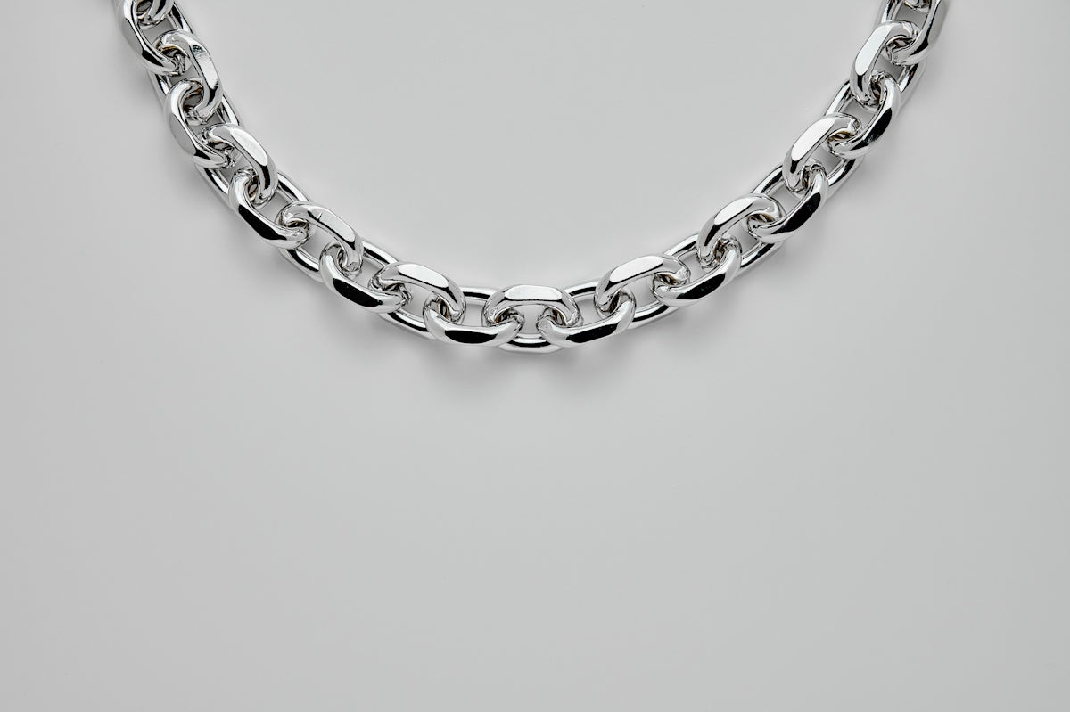 silver chain link bracelet on white surface