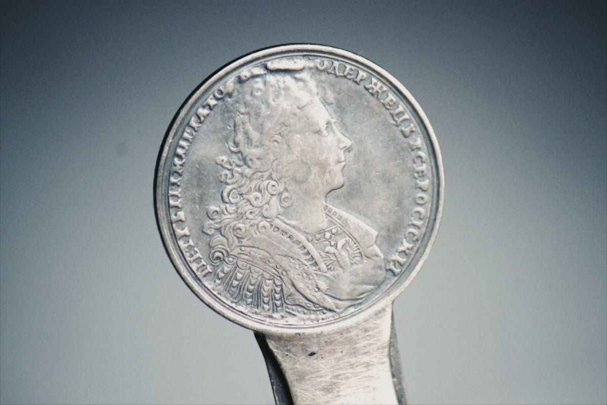 silver round coin on white surface
