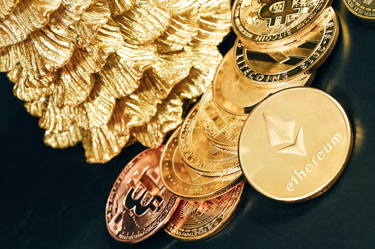 a pile of gold and silver bitcoins next to a pile of gold and