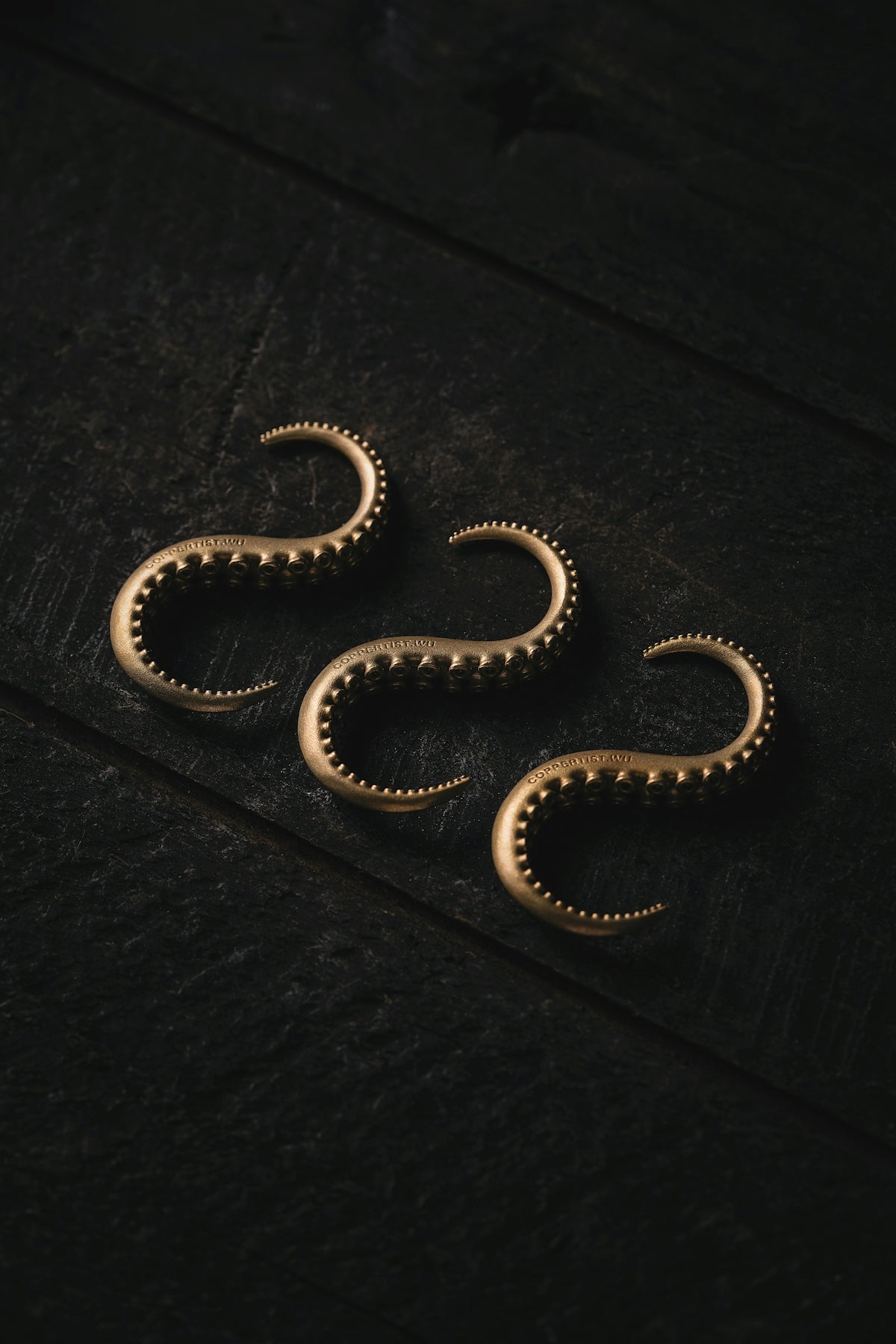 three gold rings sitting on top of a wooden table