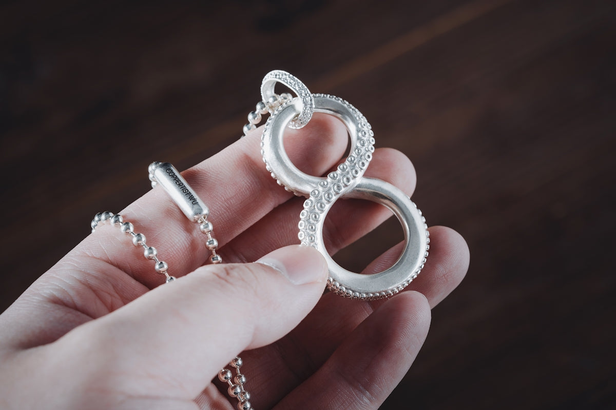 a person is holding a pair of silver rings