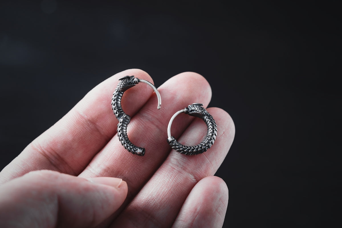 a person holding a pair of earrings in their hand