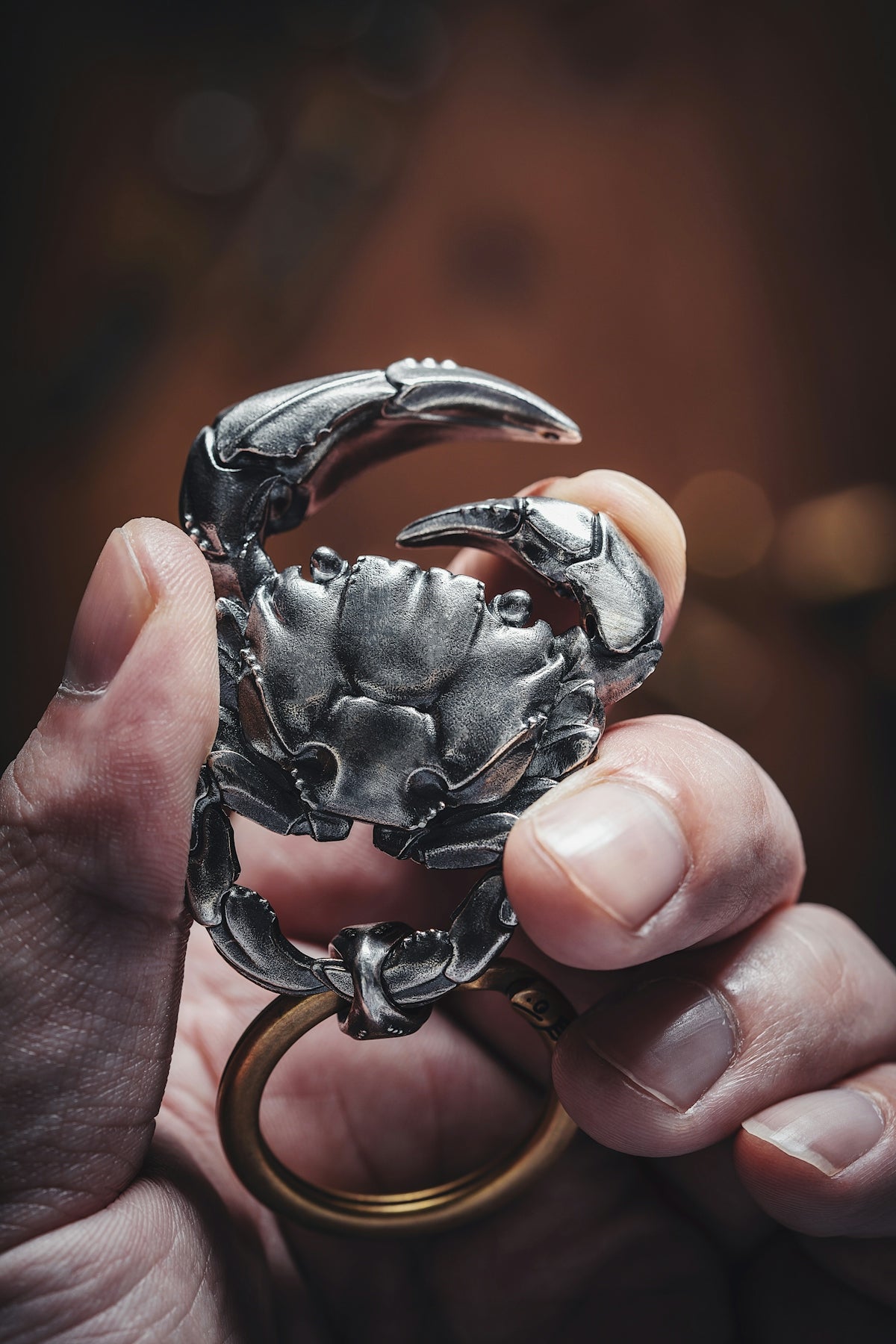 a person holding a ring with a crab on it