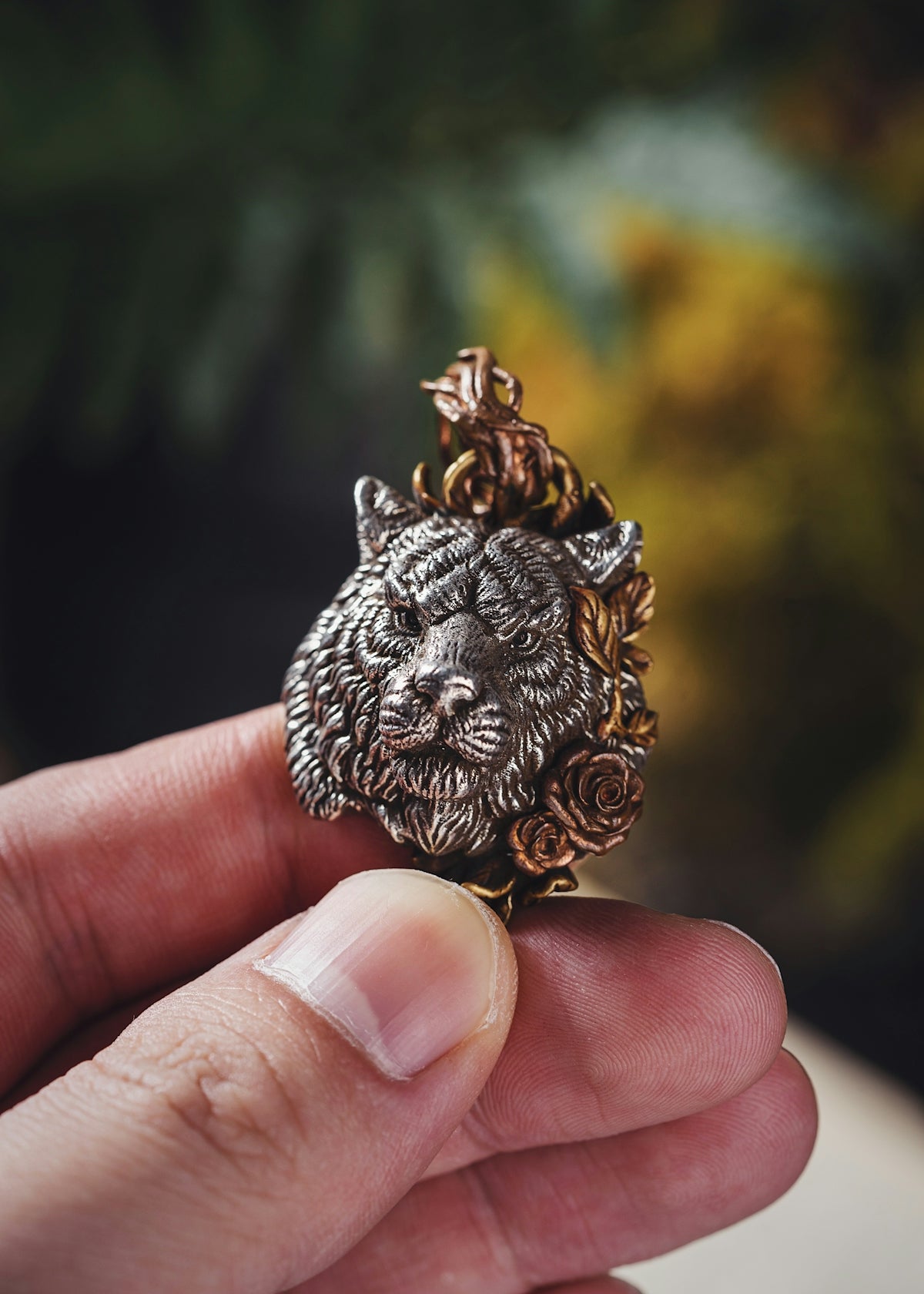 a person holding a lion head ring in their hand