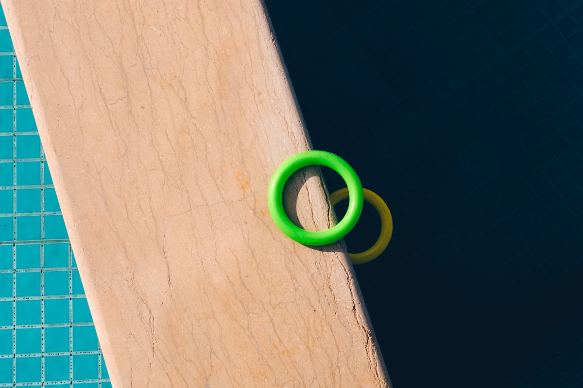 a pair of green rings sitting on top of a swimming pool