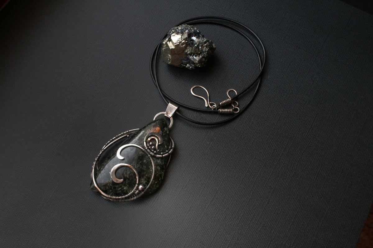 a necklace with a pendant and a rock on a table