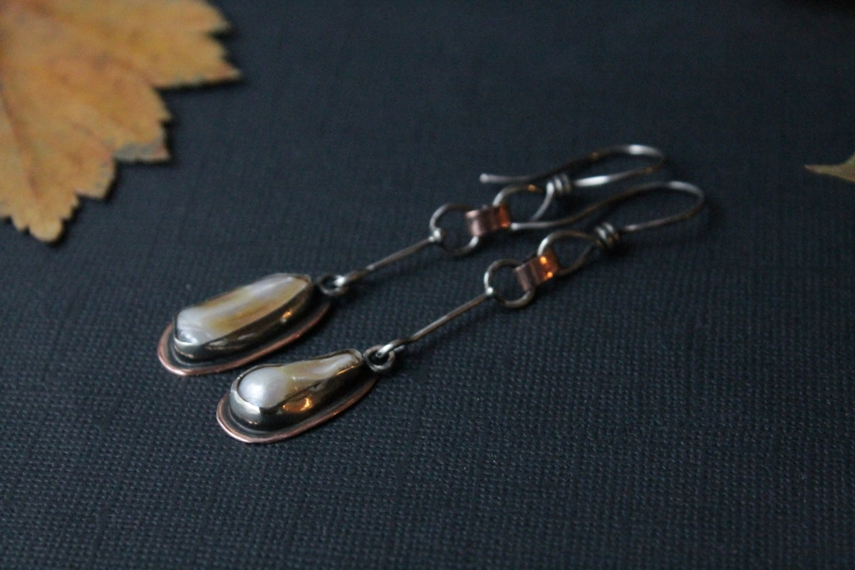 a pair of silver spoons sitting on top of a table