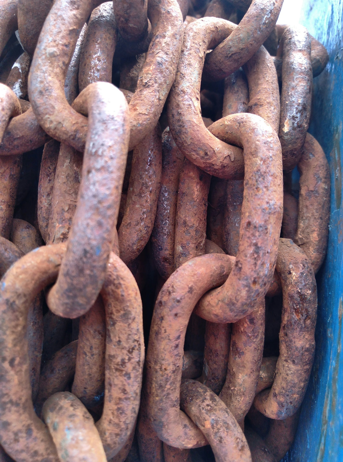 a large group of rusty chains in a blue container