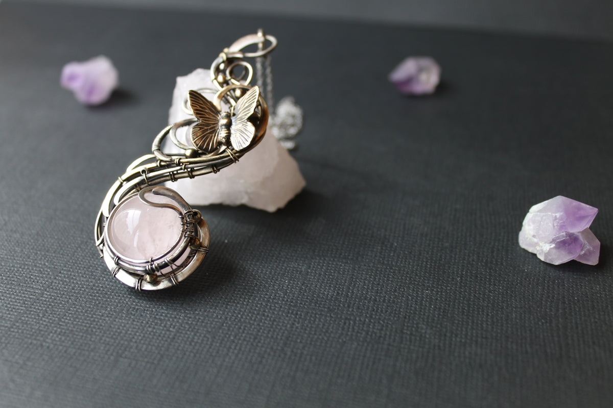 a pair of earrings sitting on top of a rock