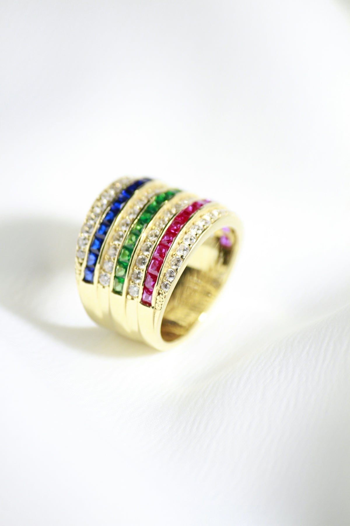a gold ring with multicolored stones on it