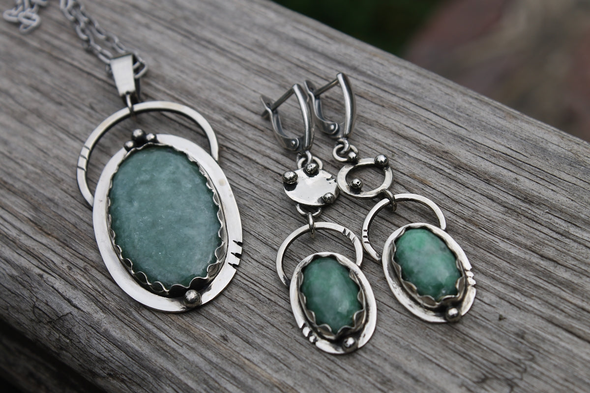 Three pieces of jewelry sitting on top of a wooden table