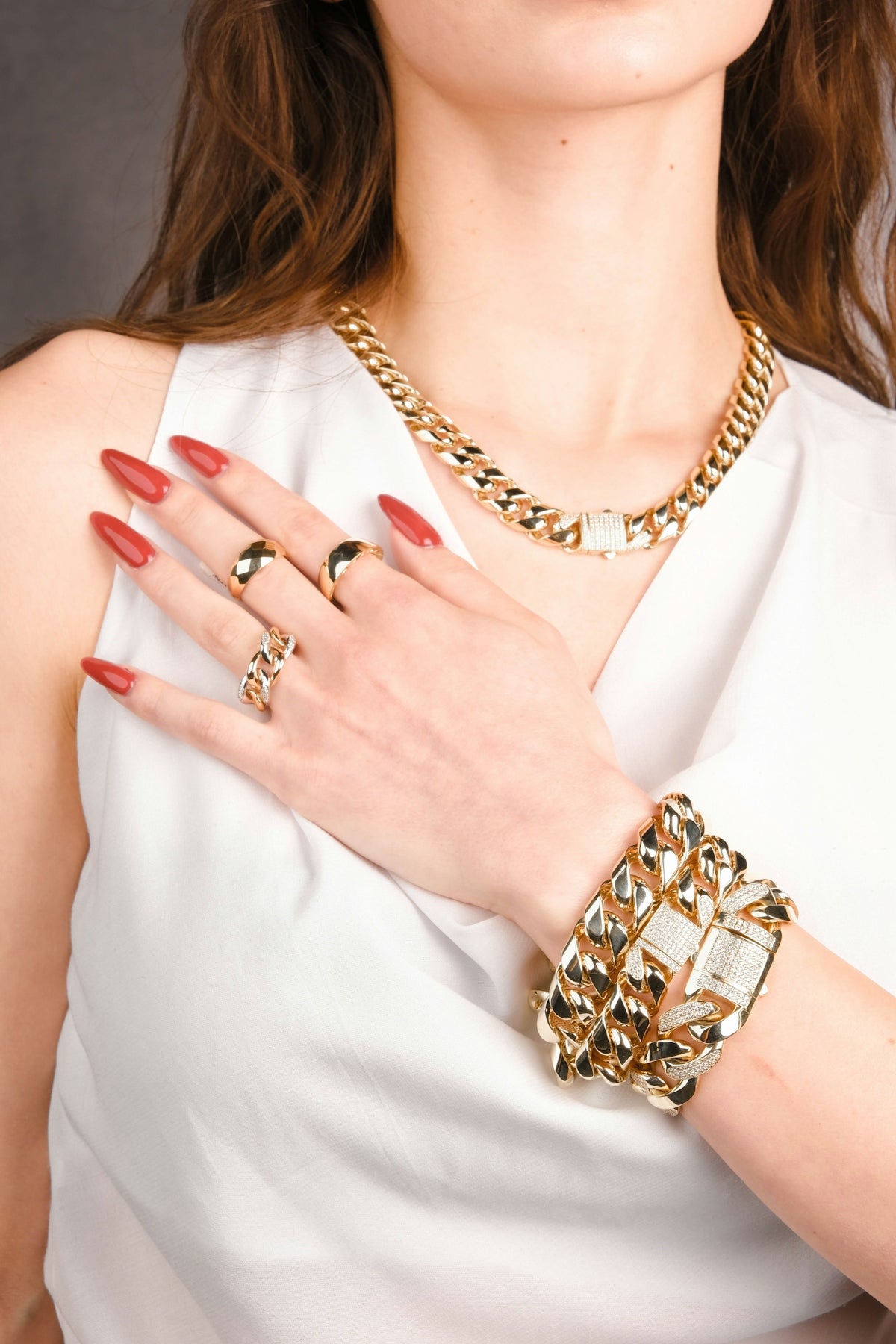 A woman wearing a white dress and gold jewelry