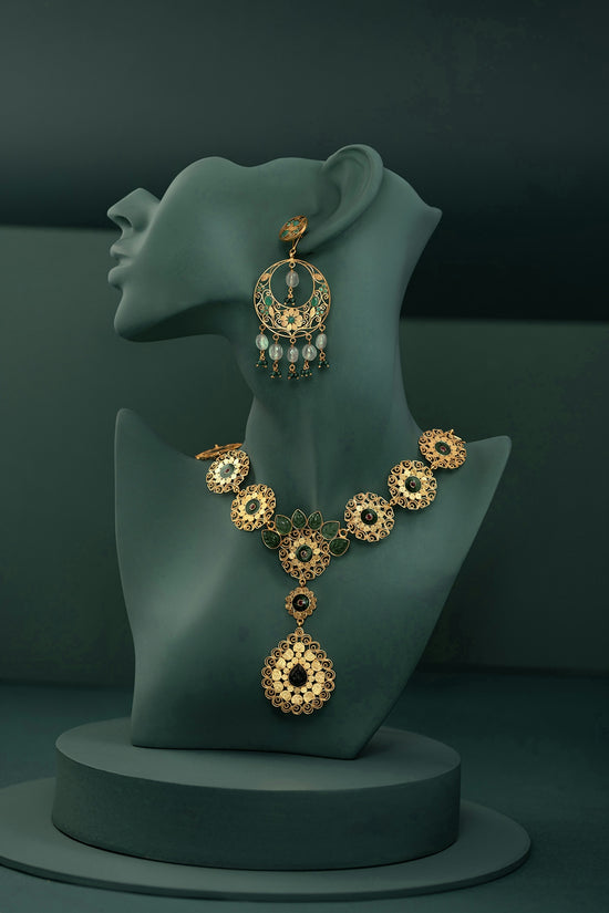 A necklace and earring on display on a mannequin