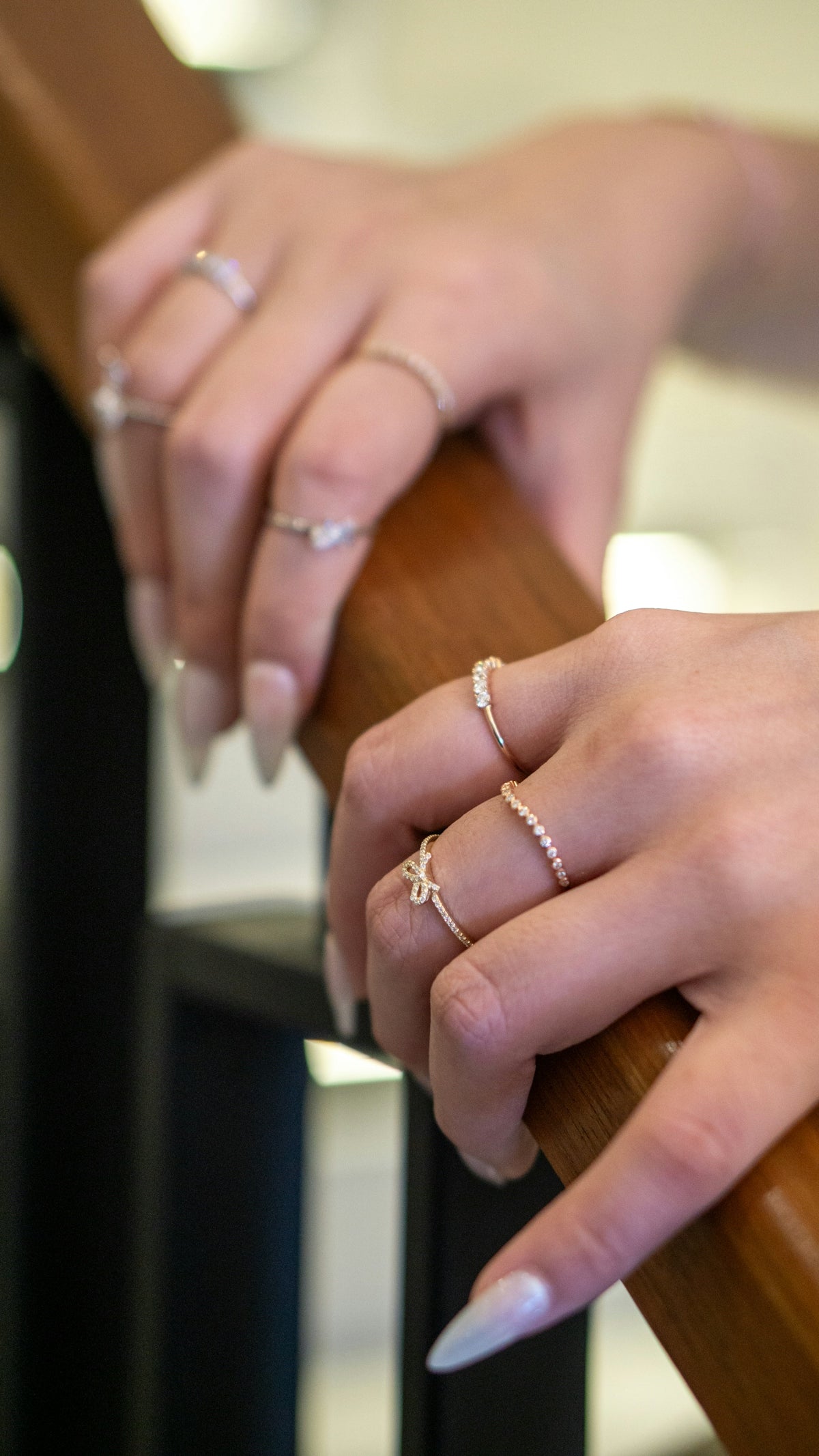 A woman's hand holding onto a wooden rail