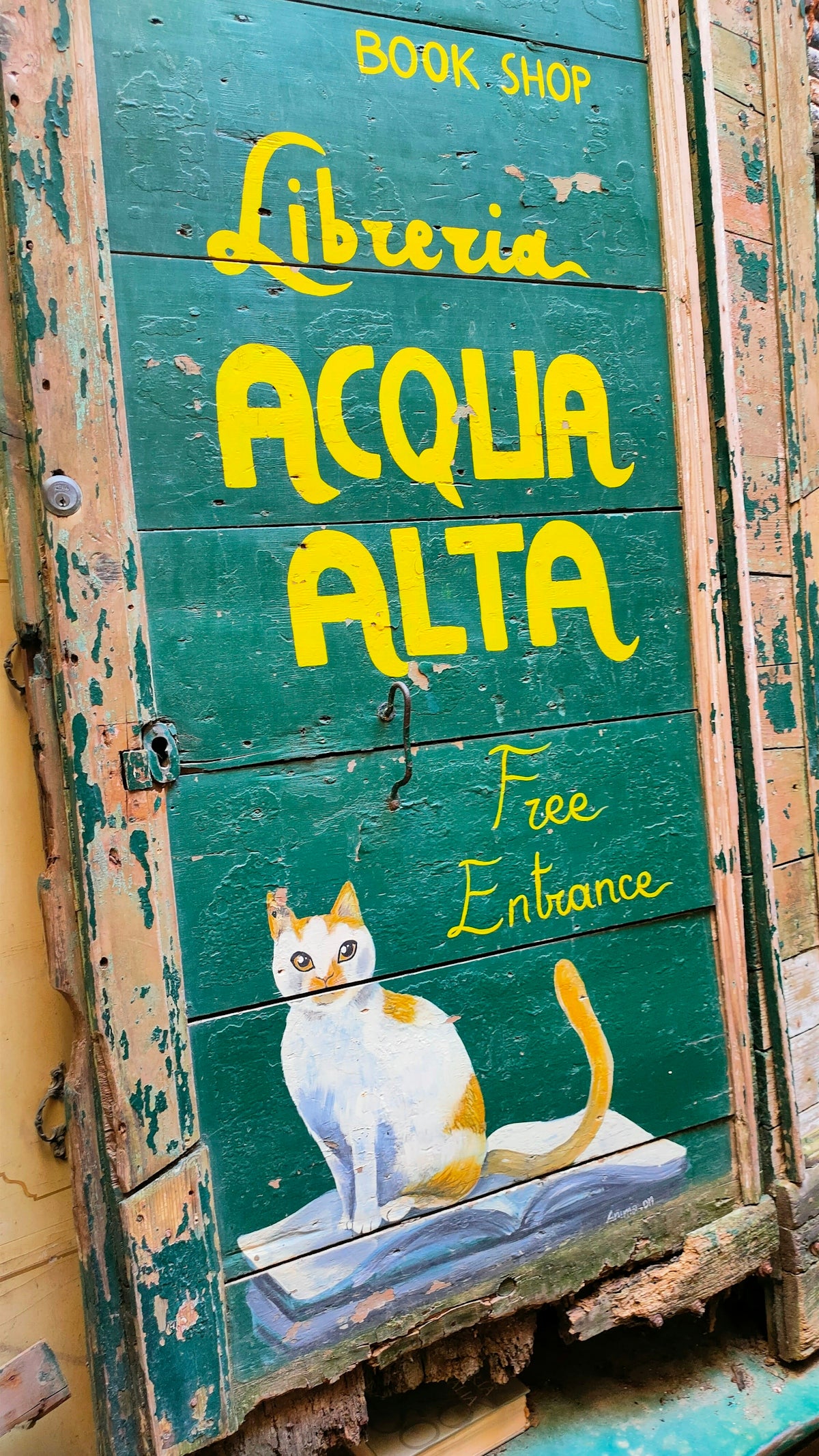 A book shop sign with a cat painted on it