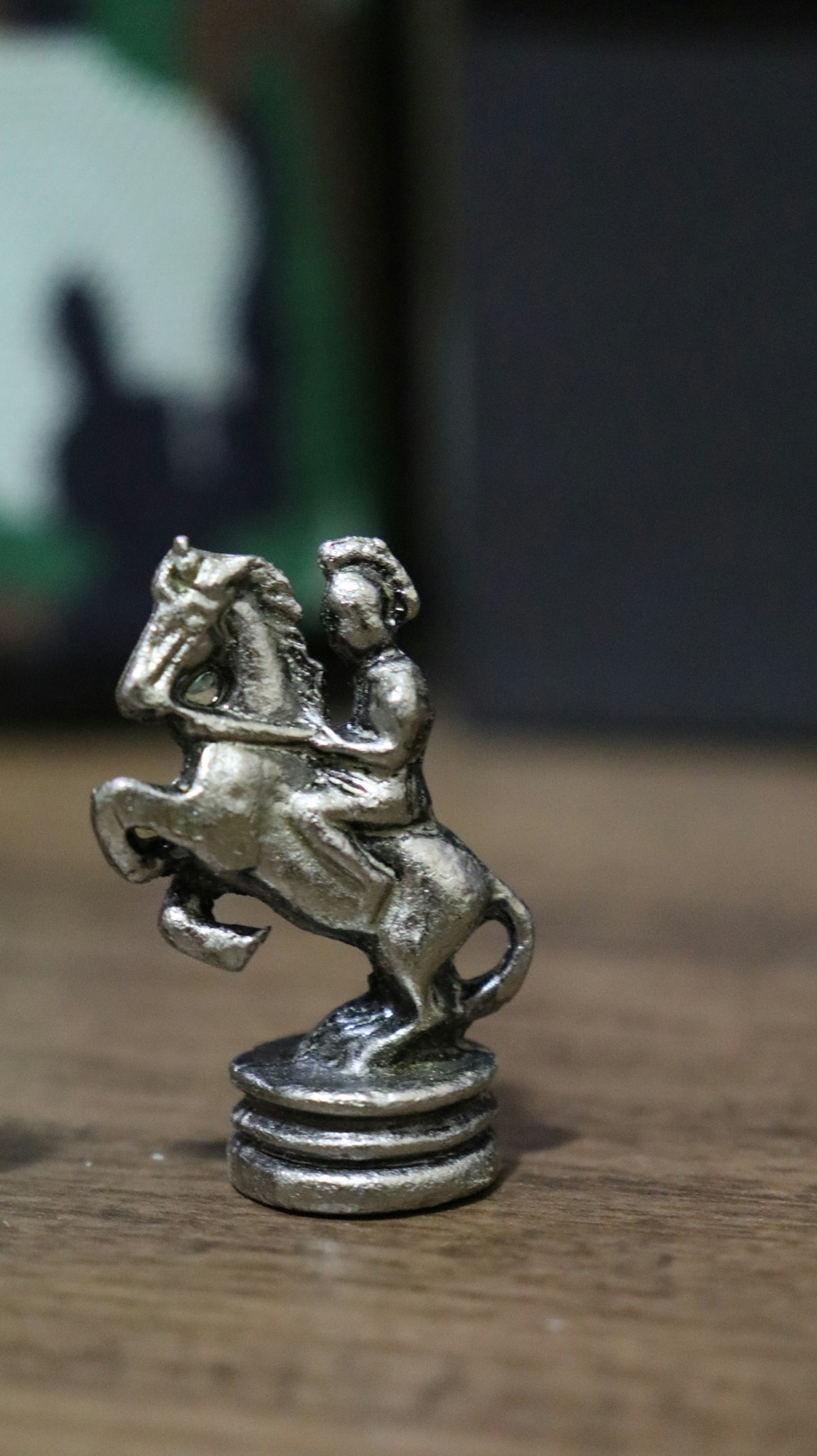 A silver statue of a horse and rider on a wooden table