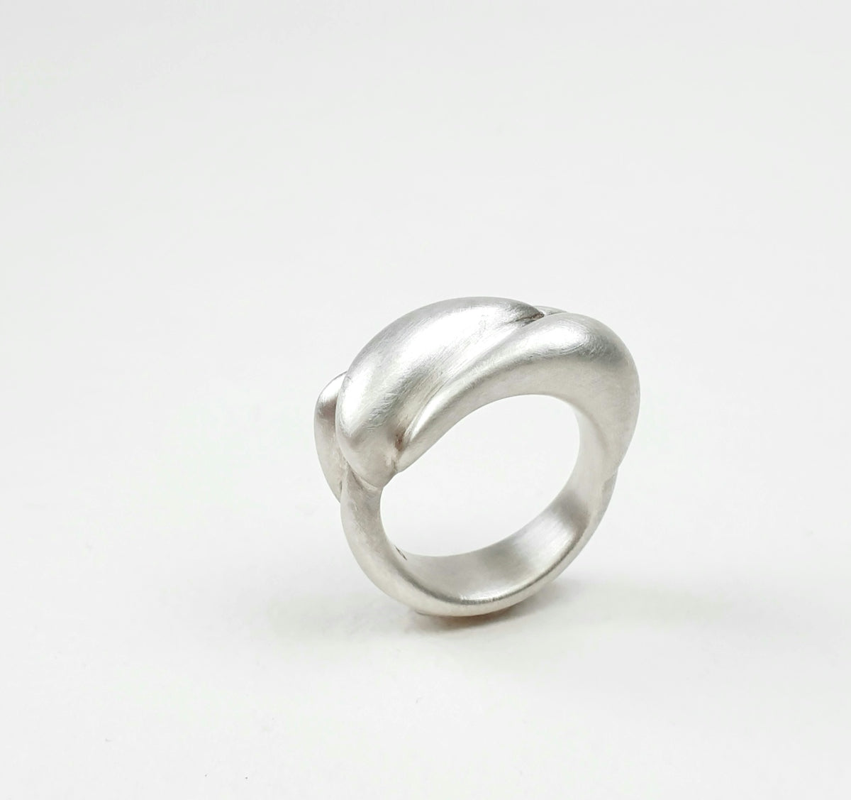 A silver ring sitting on top of a white surface