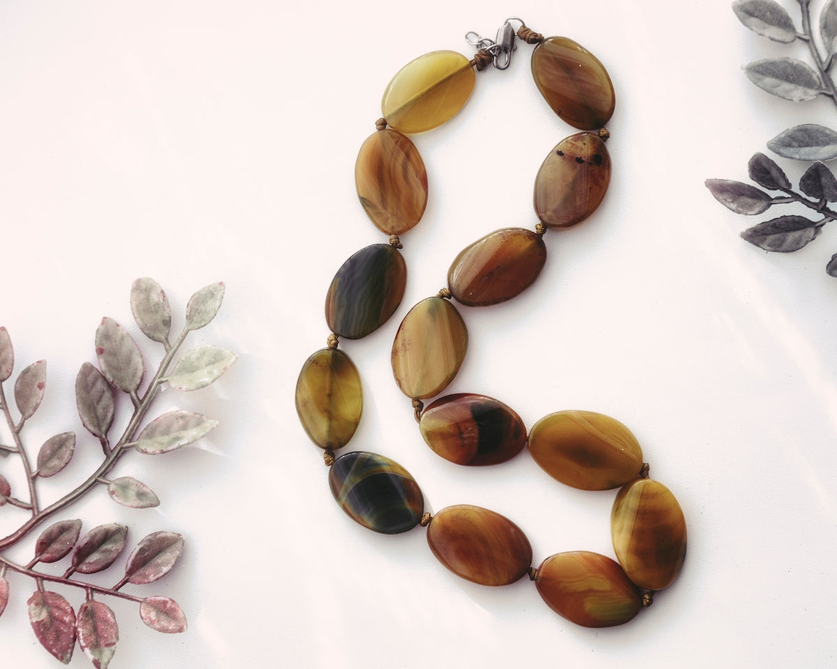 Two necklaces of different shapes and colors on a white surface