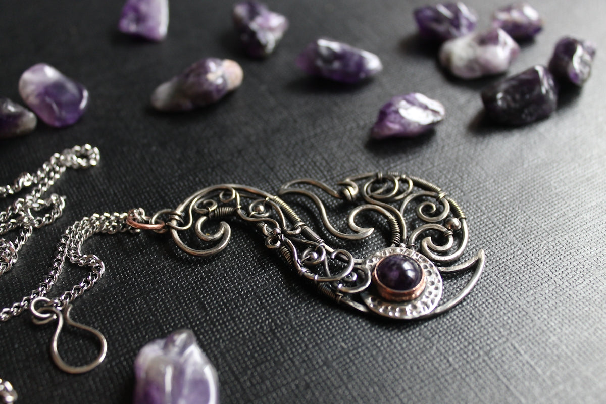 A silver necklace adorned with amethyst stones.