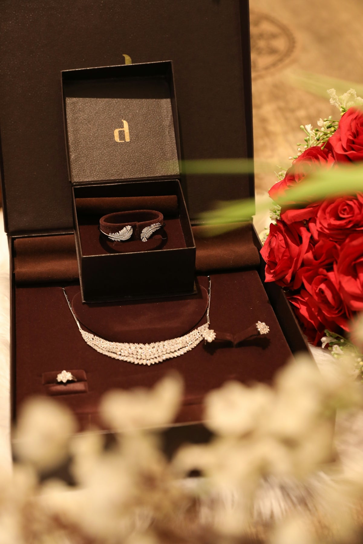Jewelry displayed inside a box with flowers.