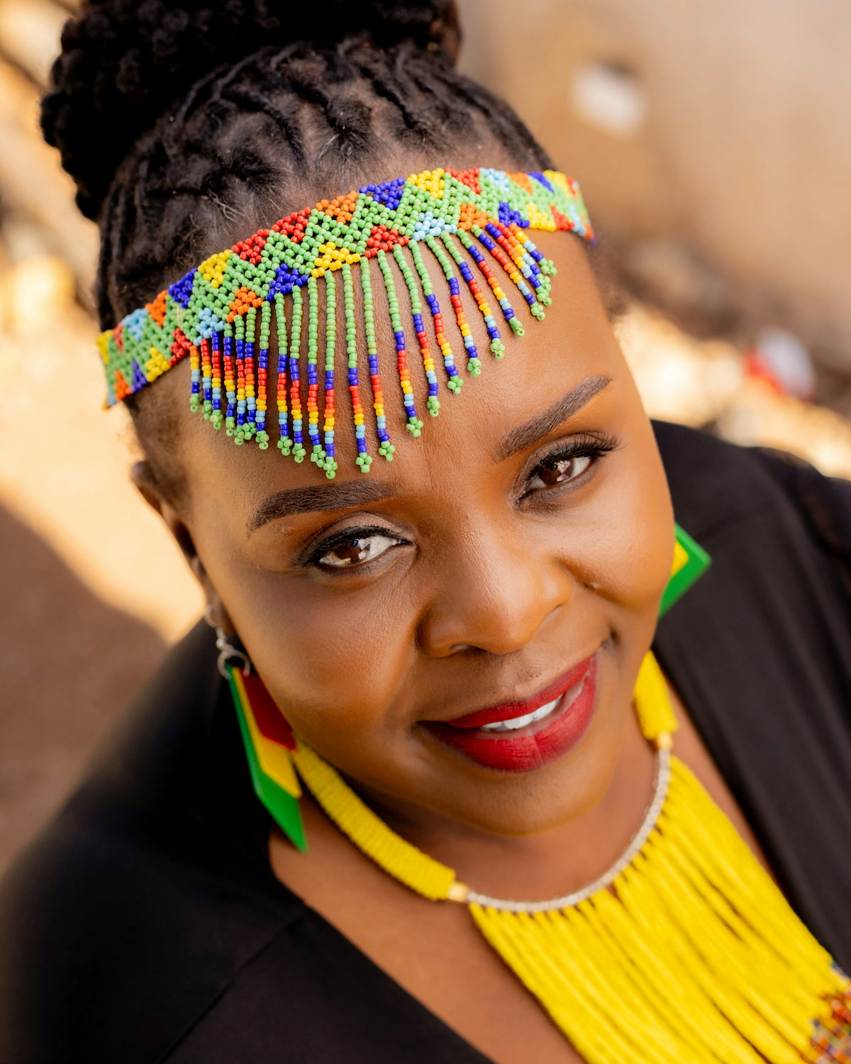 Woman wearing colorful beaded headband and jewelry.