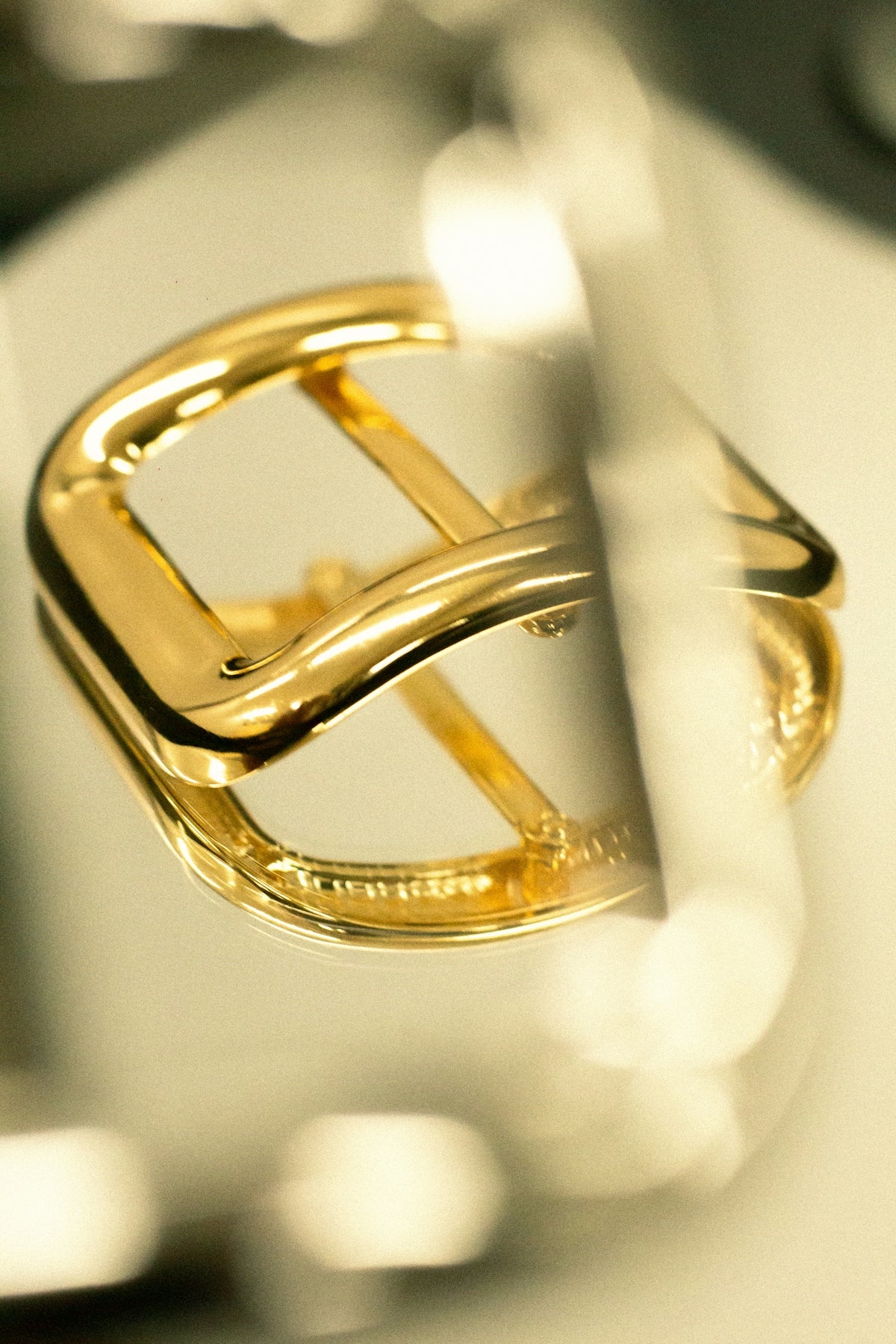 A shiny gold buckle reflects on a surface