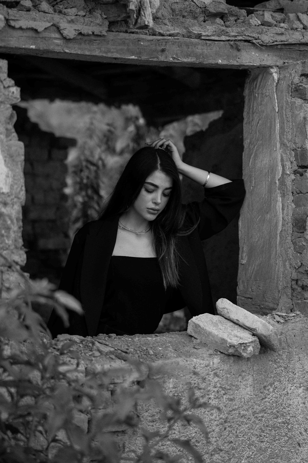 Woman in black dress looking down in stone window