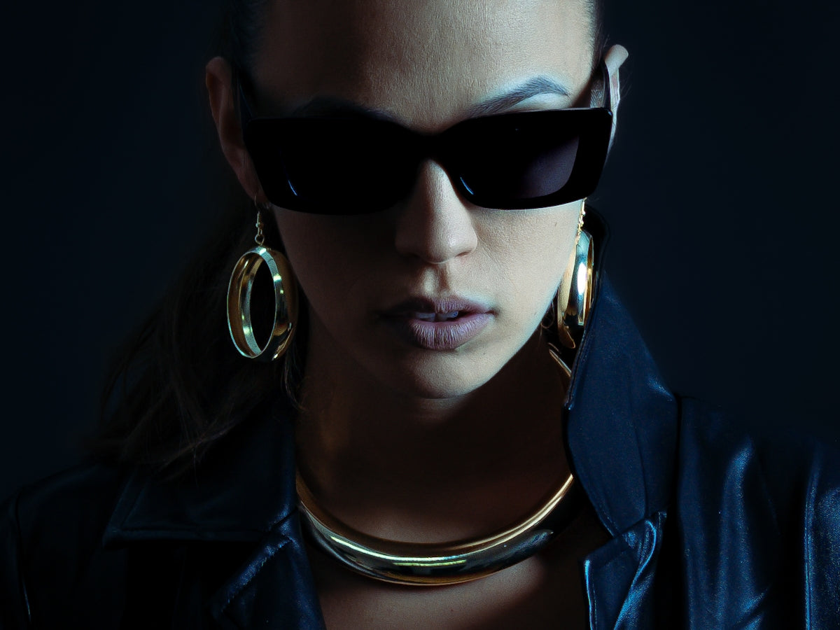 Woman wearing sunglasses and gold jewelry