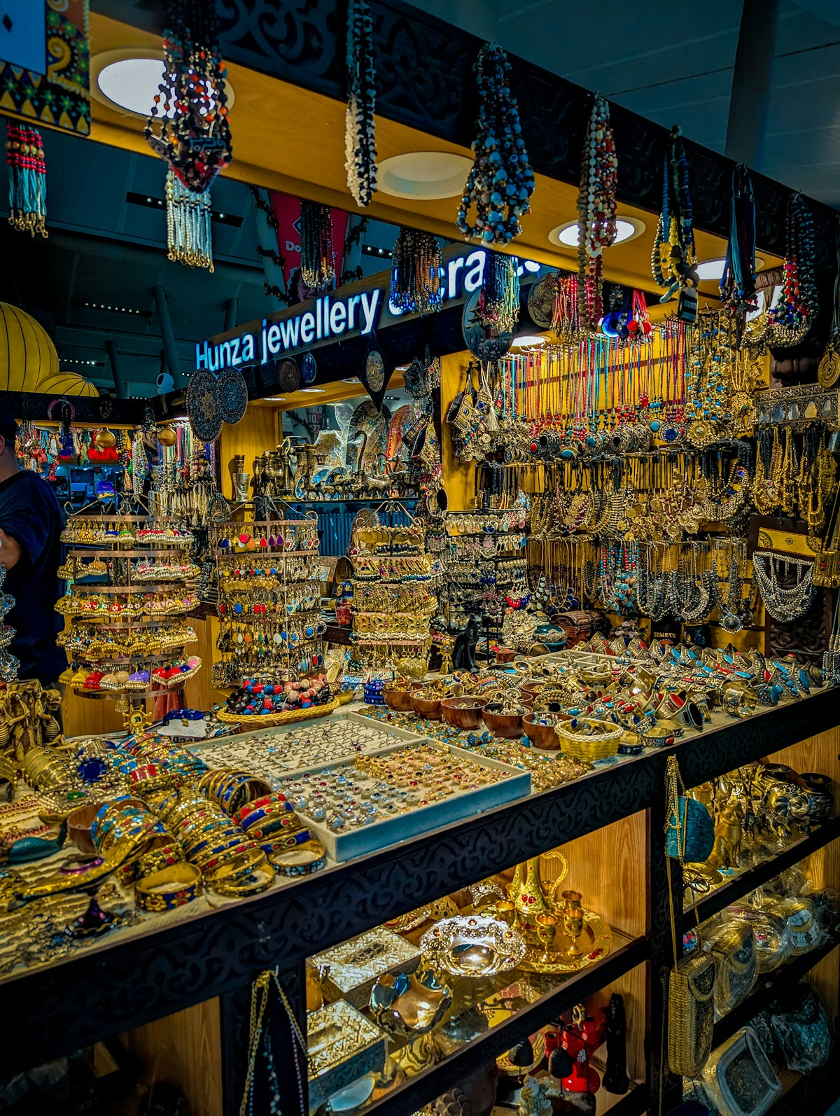 Jewelry stall with necklaces, bracelets, and earrings displayed.