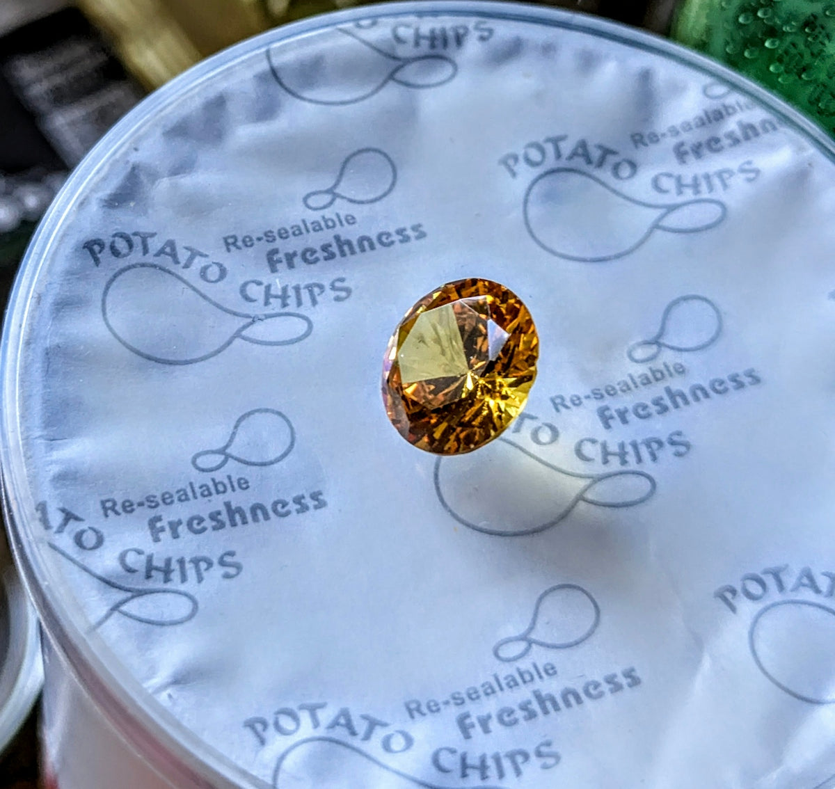 A faceted yellow gemstone on potato chip packaging.