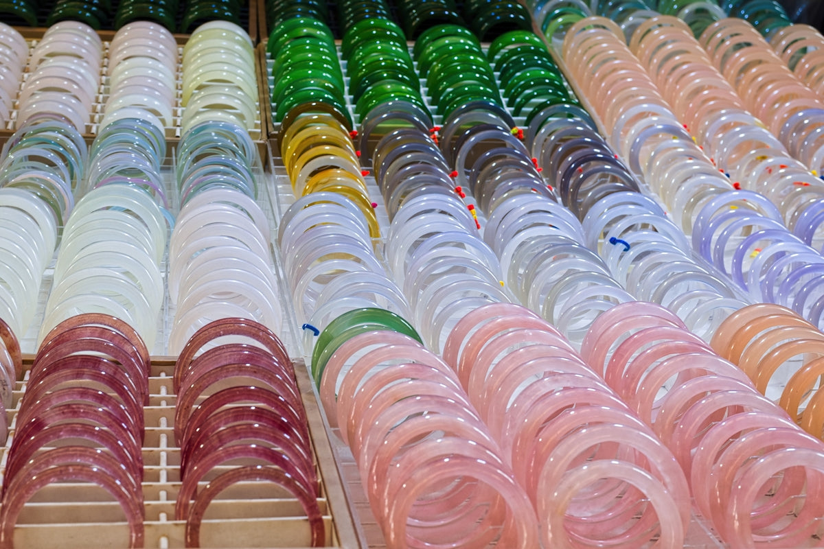 Rows of colorful bracelets displayed for sale.