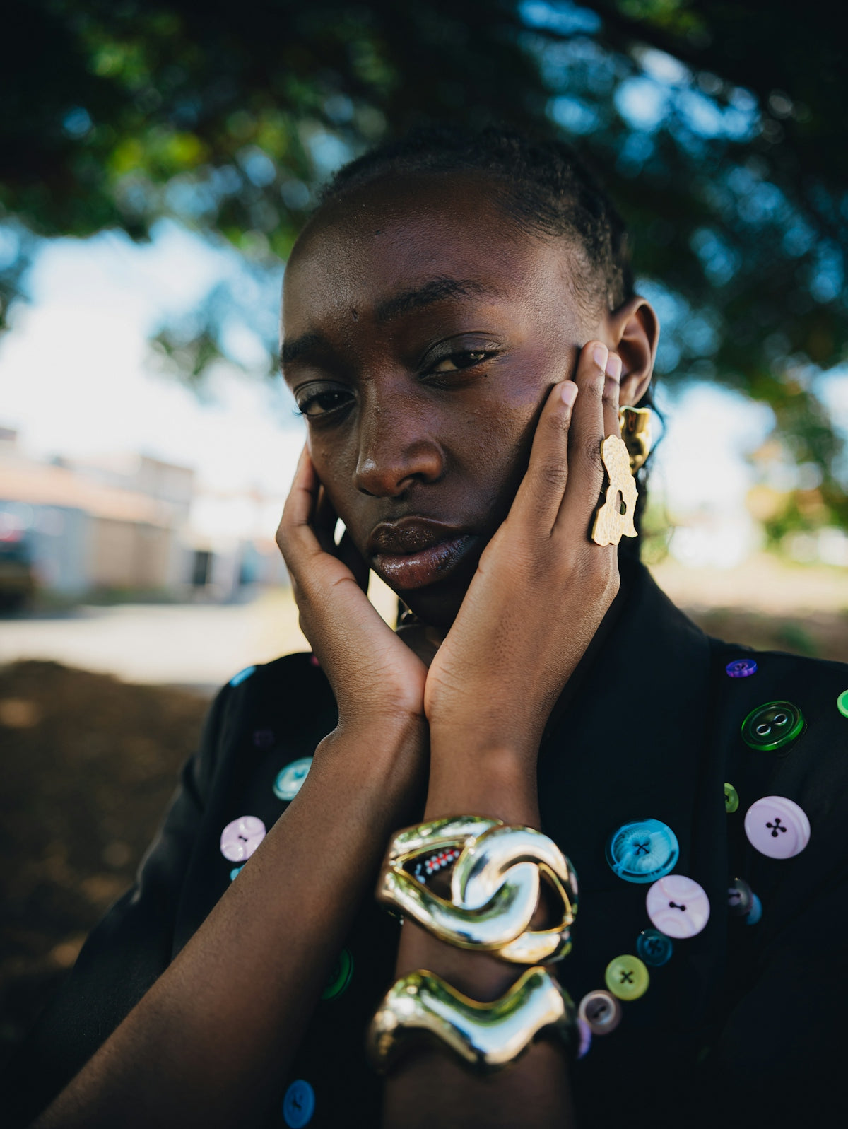 Woman with large gold jewelry and buttoned jacket