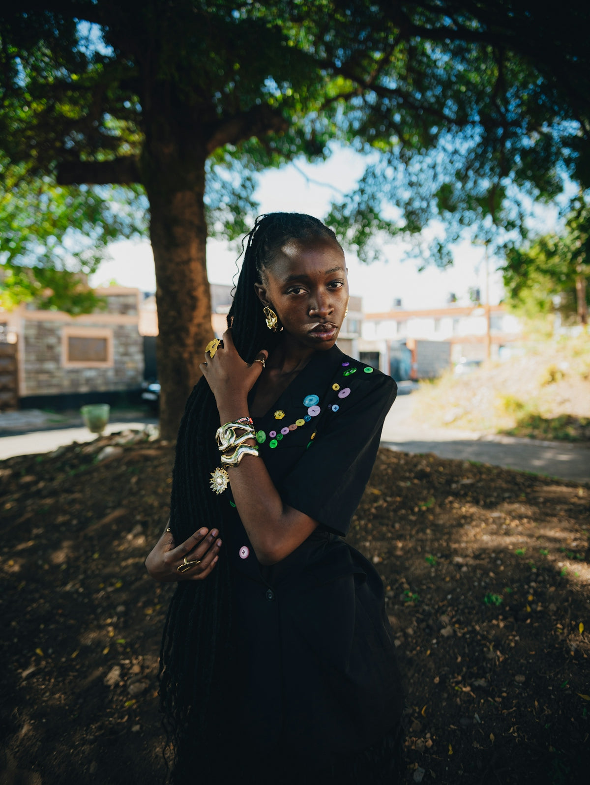 A young black woman with elaborate jewelry outdoors.