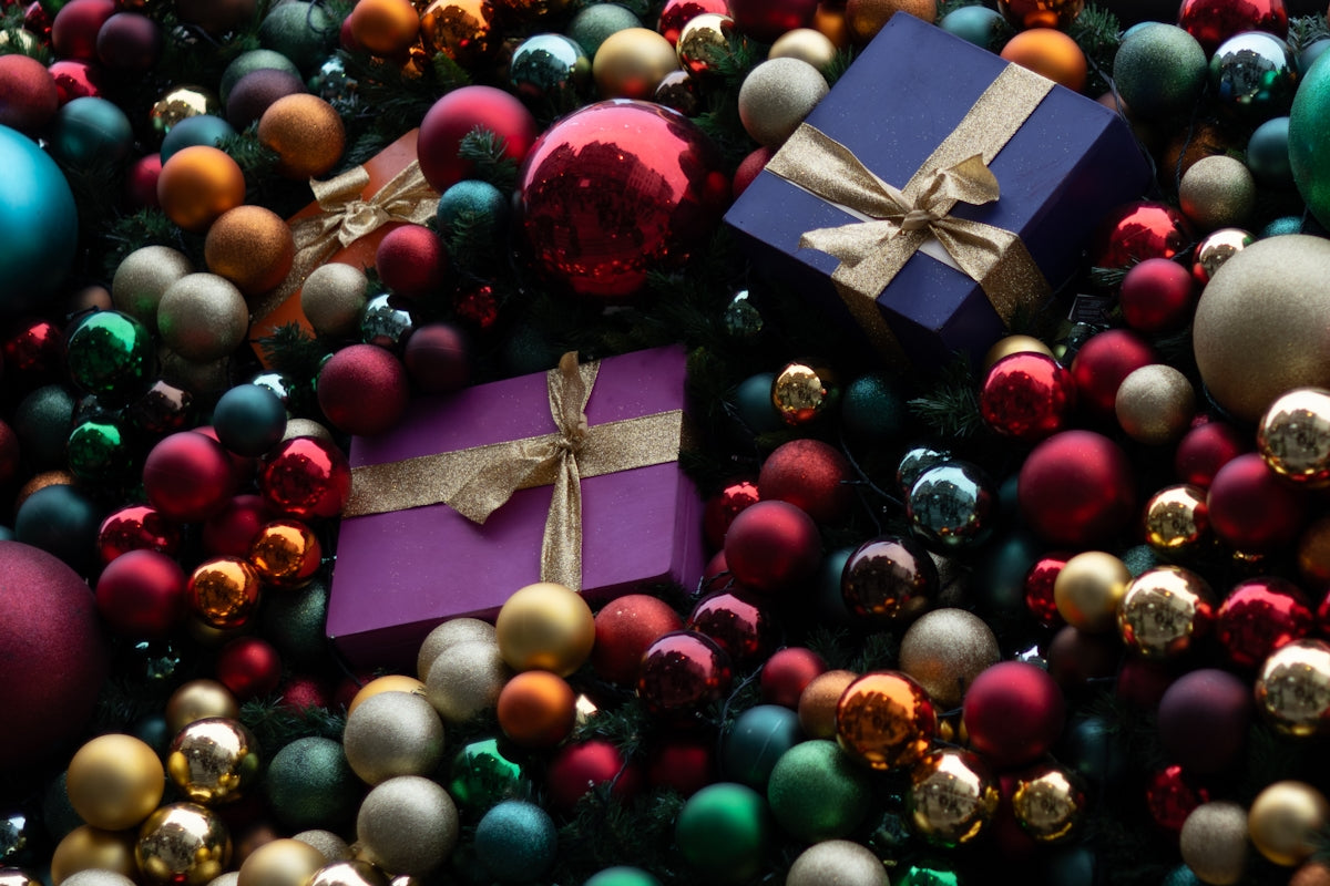Colorful christmas ornaments and gift boxes fill the frame.