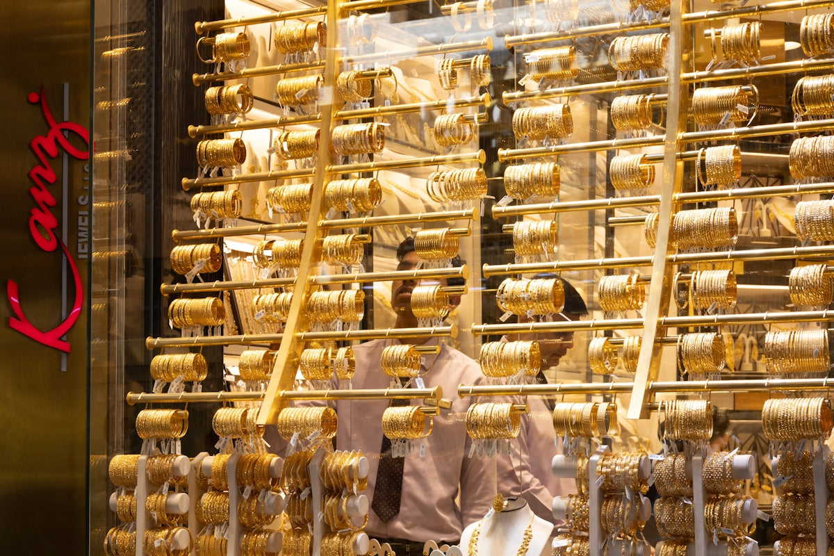 Display of numerous gold bracelets in a jewelry store.