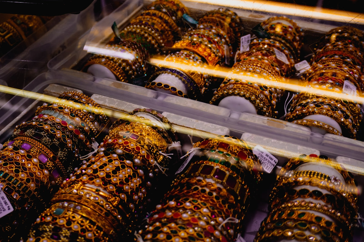 Rows of ornate, jeweled bangles displayed in a case.