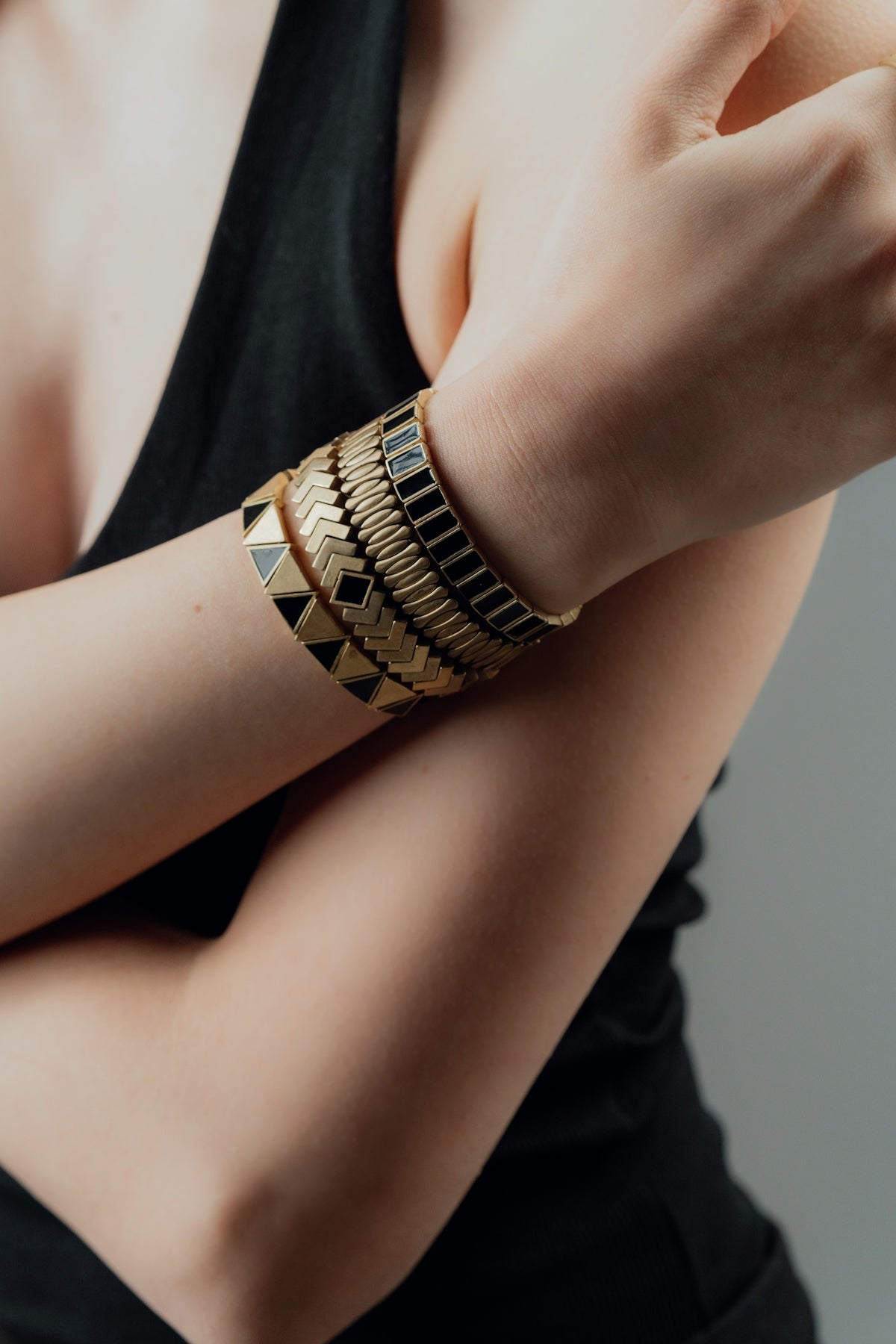 Woman wearing stacked gold and black bracelets