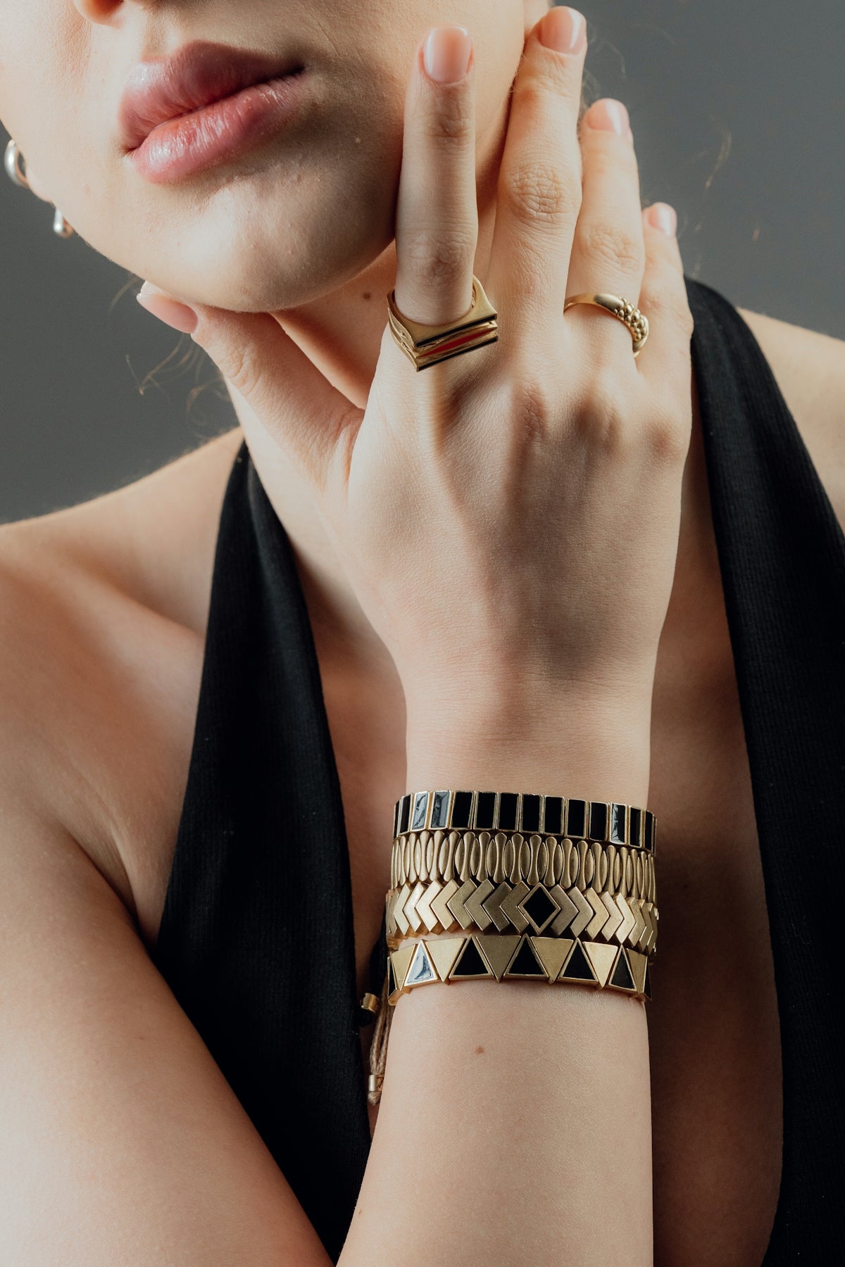 Woman wearing stacked gold bracelets and rings