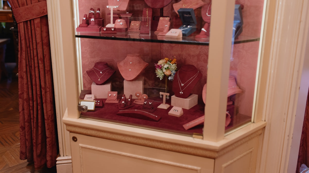 Elegant jewelry collection displayed in a lighted glass cabinet.